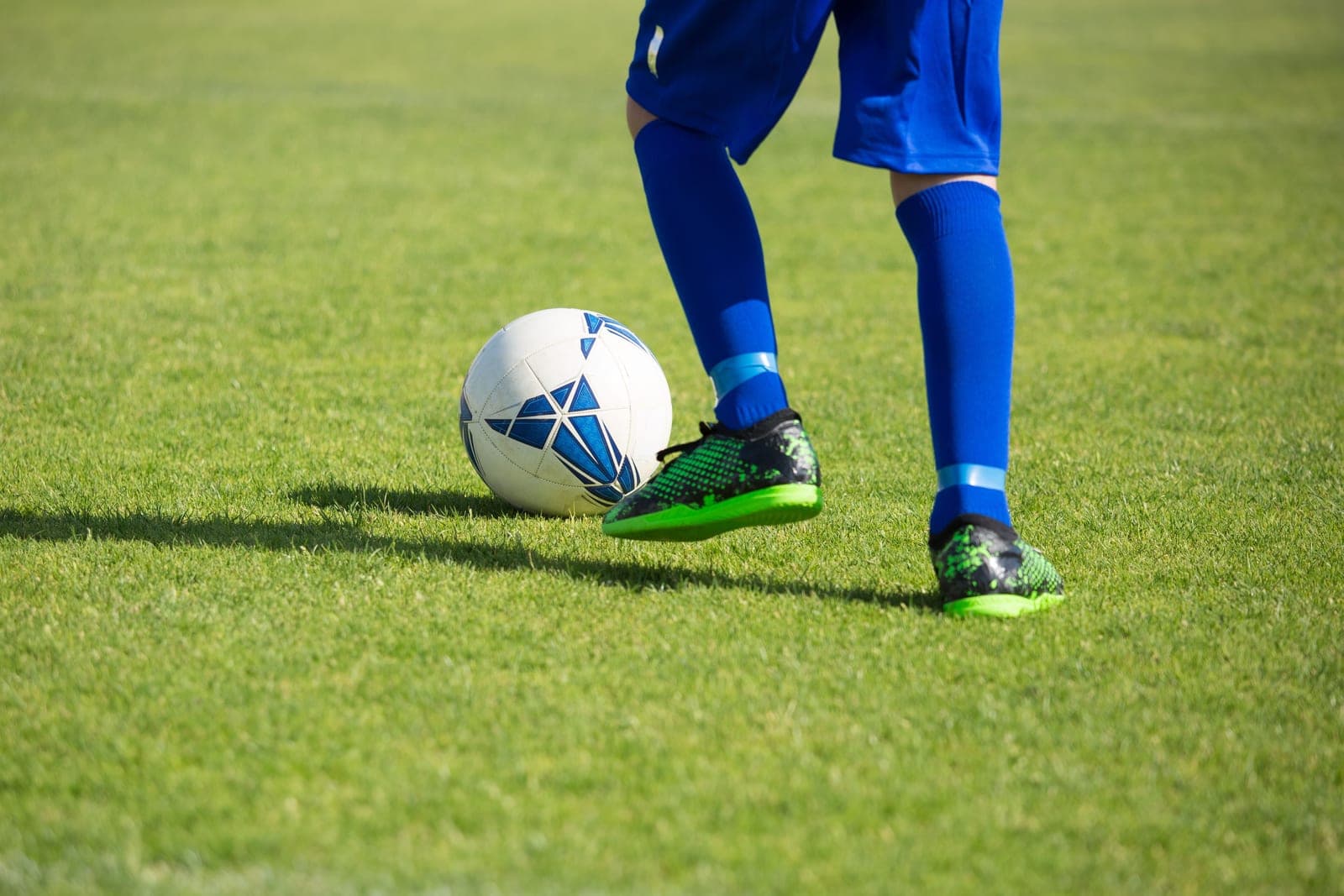 Soccer cleats resting on cut grass